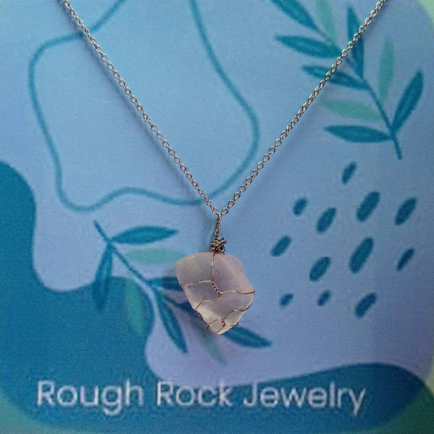 Necklace with a rough rock pendant on a blue background with 'Rough Rock Jewelry' text.