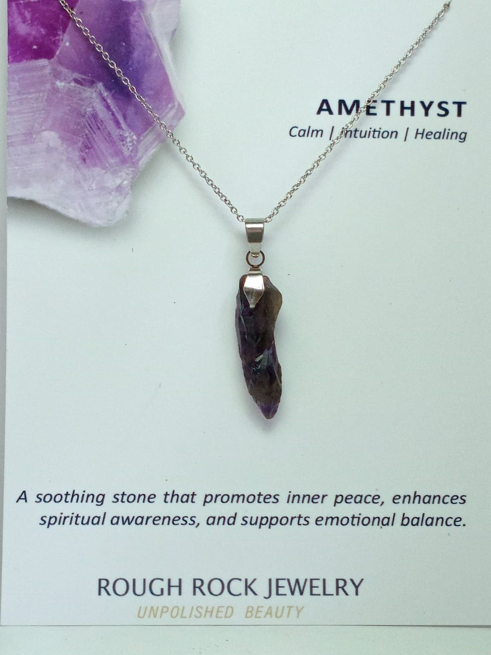 Amethyst pendant necklace on a card with text about its properties.