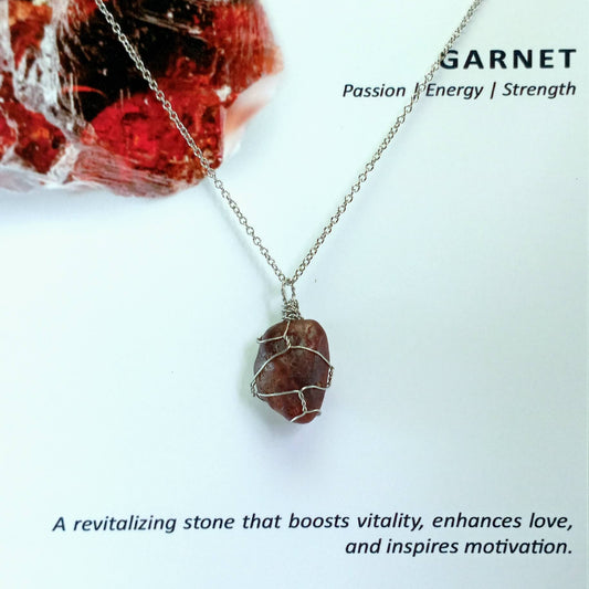 Garnet necklace with rough rock pendant on a light blue background, featuring text about garnet's properties.
