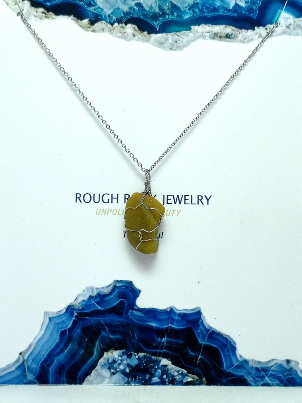 Necklace with a green opal stone pendant on a white background with blue decorative elements.