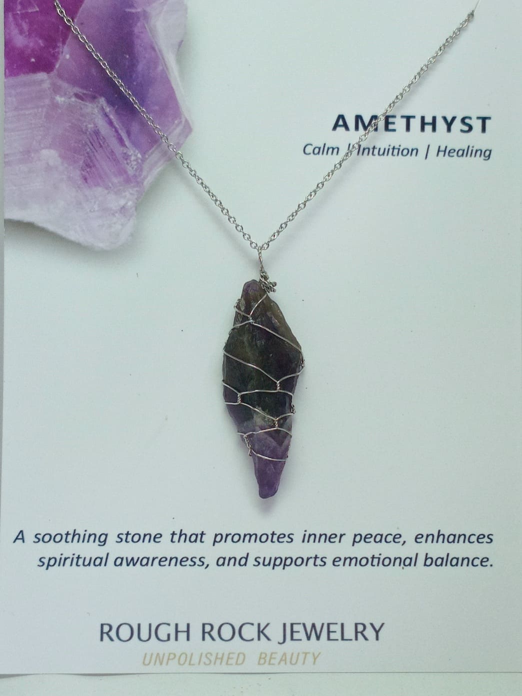 Amethyst pendant necklace on a card with text about amethyst properties and Rough Rock Jewelry branding.