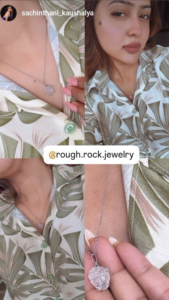 Person wearing a floral outfit with a necklace featuring a large pendant, branded 'rough.rock.jewelry'.