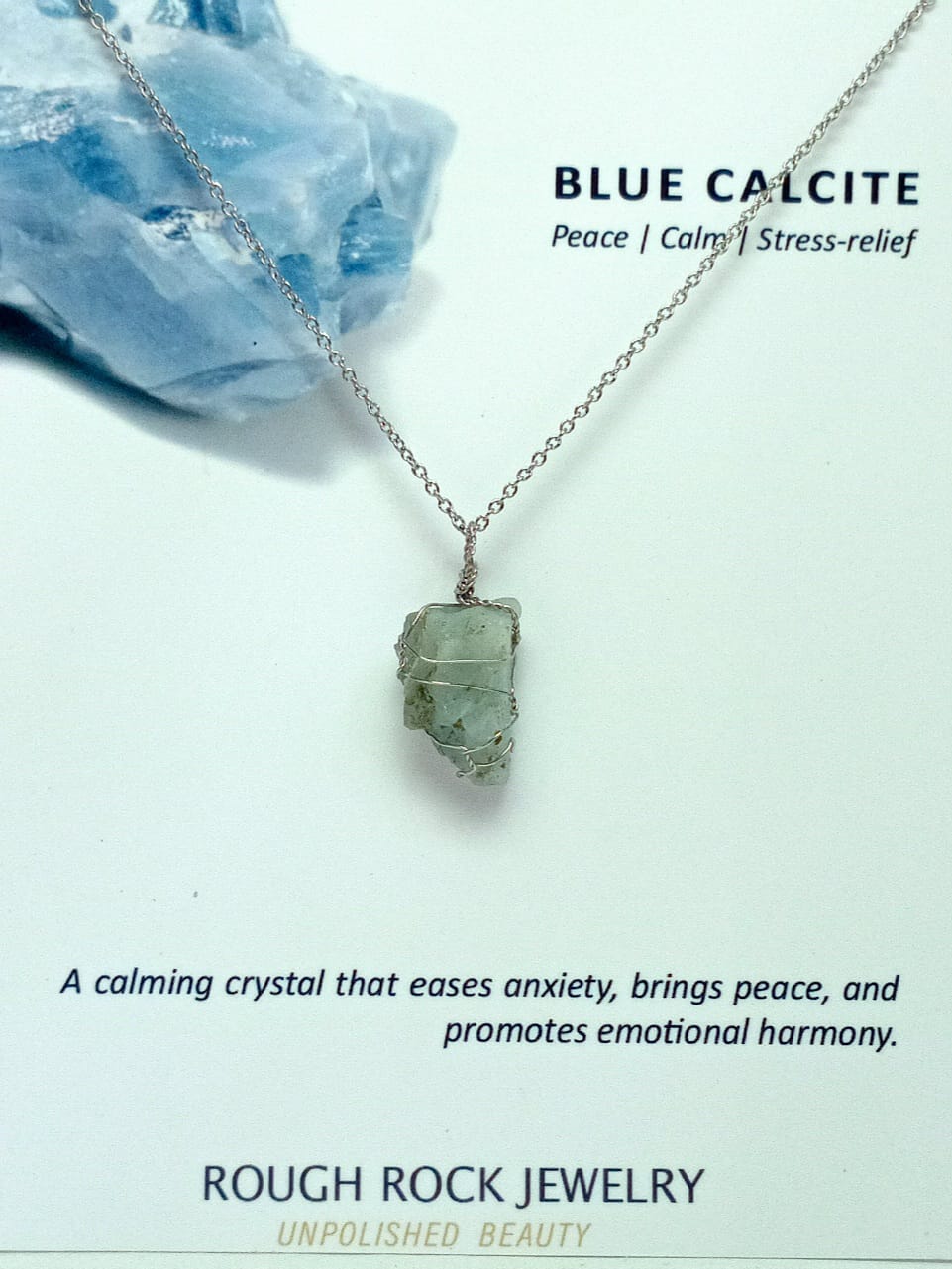 Blue calcite crystal necklace with text on a light background